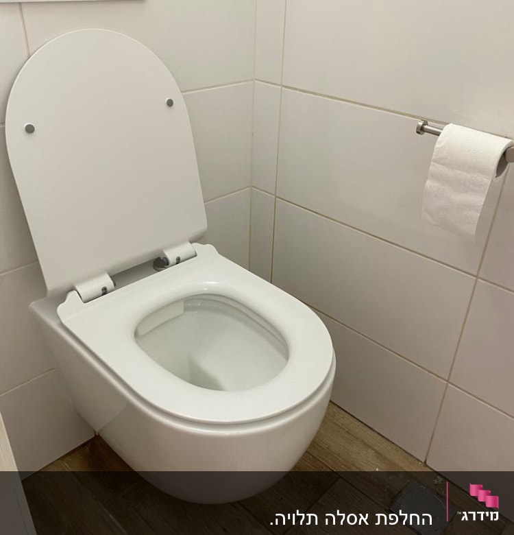 אסלה תלויה על קיר עם נייר טואלט